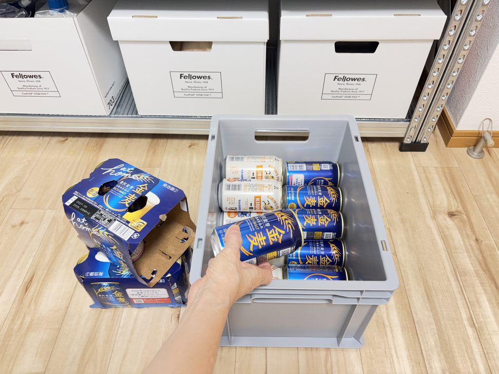 ビール缶を横に寝かせてケースに入れている手元